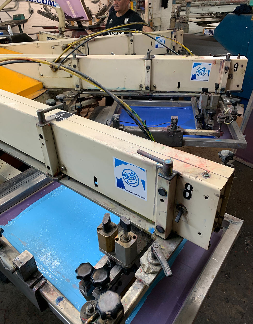 Close-up view of a screen printing frame with ink being applied