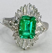 A white gold ring set with a green emerald