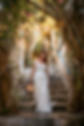 Bride walking down stone stairs beneath an arch of bougainvillea in Byblos, wedding photography Lebanon
