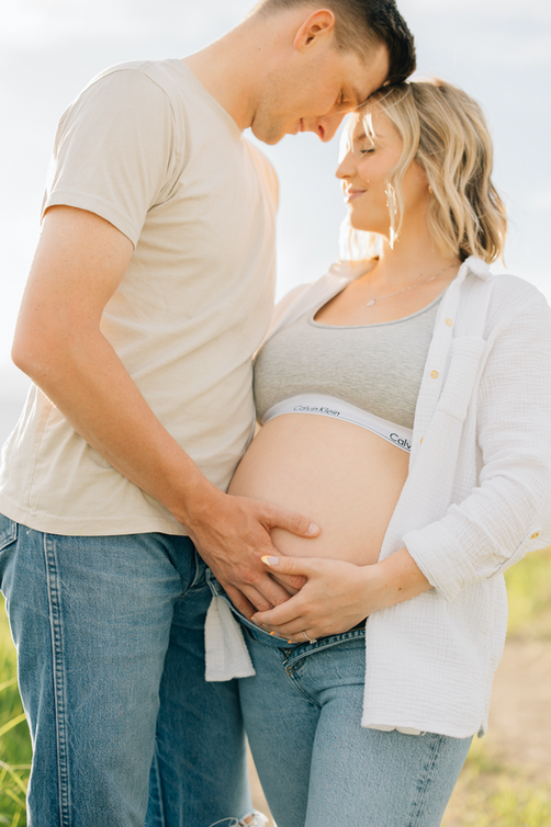 Pregnant couple embracing during a lifestyle maternity session