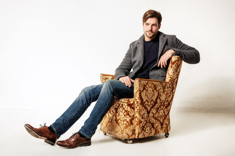 Photo of a man sitting in an upholstered armchair.