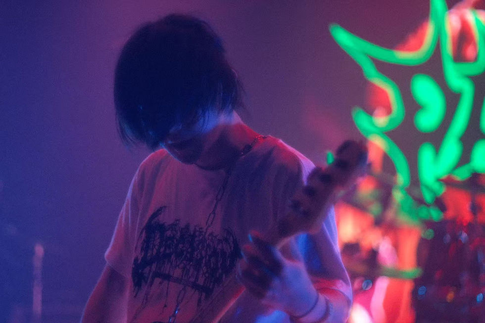 Parasitario bass player performing under dramatic atmospheric stage lighting