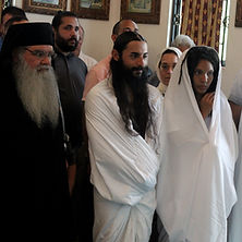 an orthodox monk stands next to three catechumens