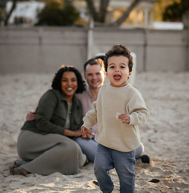 A running toddler during beach maternity photoshoot in Sydney