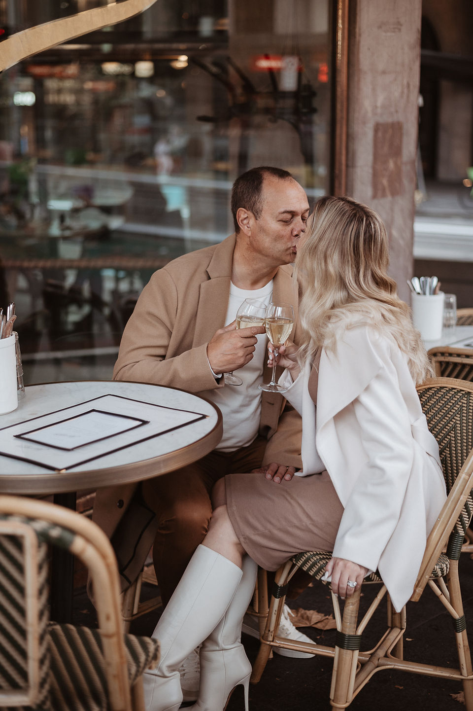 Couple sharing a drink at a Sydney CBD café during a relaxed winter couples photoshoot.