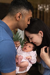 parents kissing there baby
