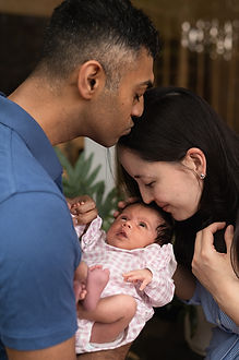 parents kissing there baby