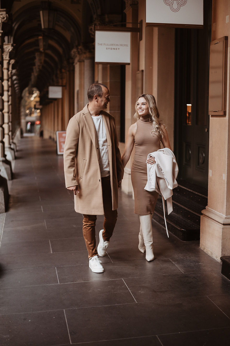 Couple walking through a covered Sydney CBD walkway during a winter city photoshoot.