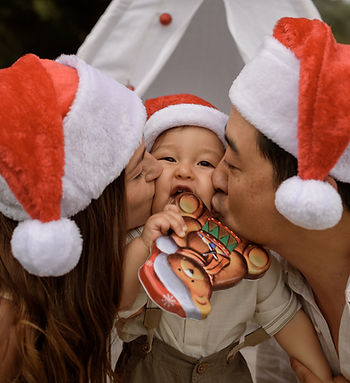Wrapped in love - parents kissing their baby son during Christmas photoshoot in Sydney