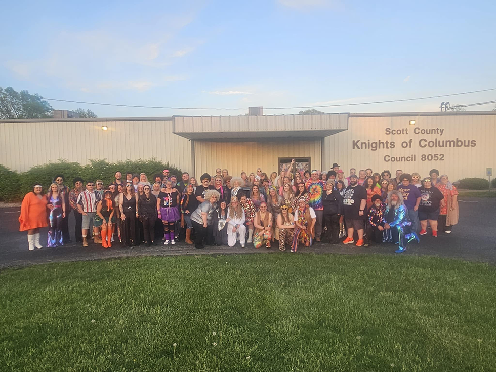 Attendees take a group photo in front of venue