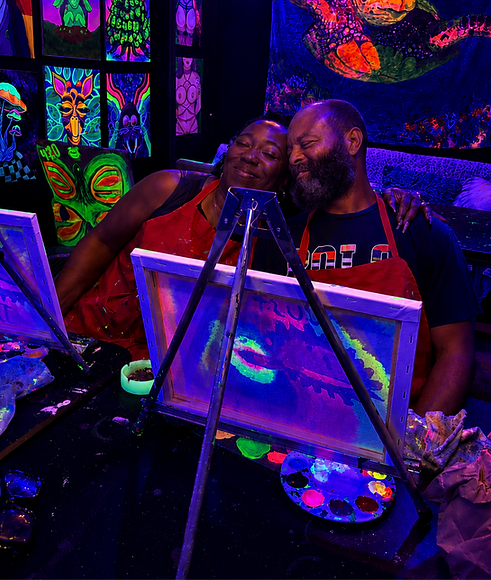 Guest smiling while painting during a private 21+ blacklight Puff & Paint party at Cherry Stoner.