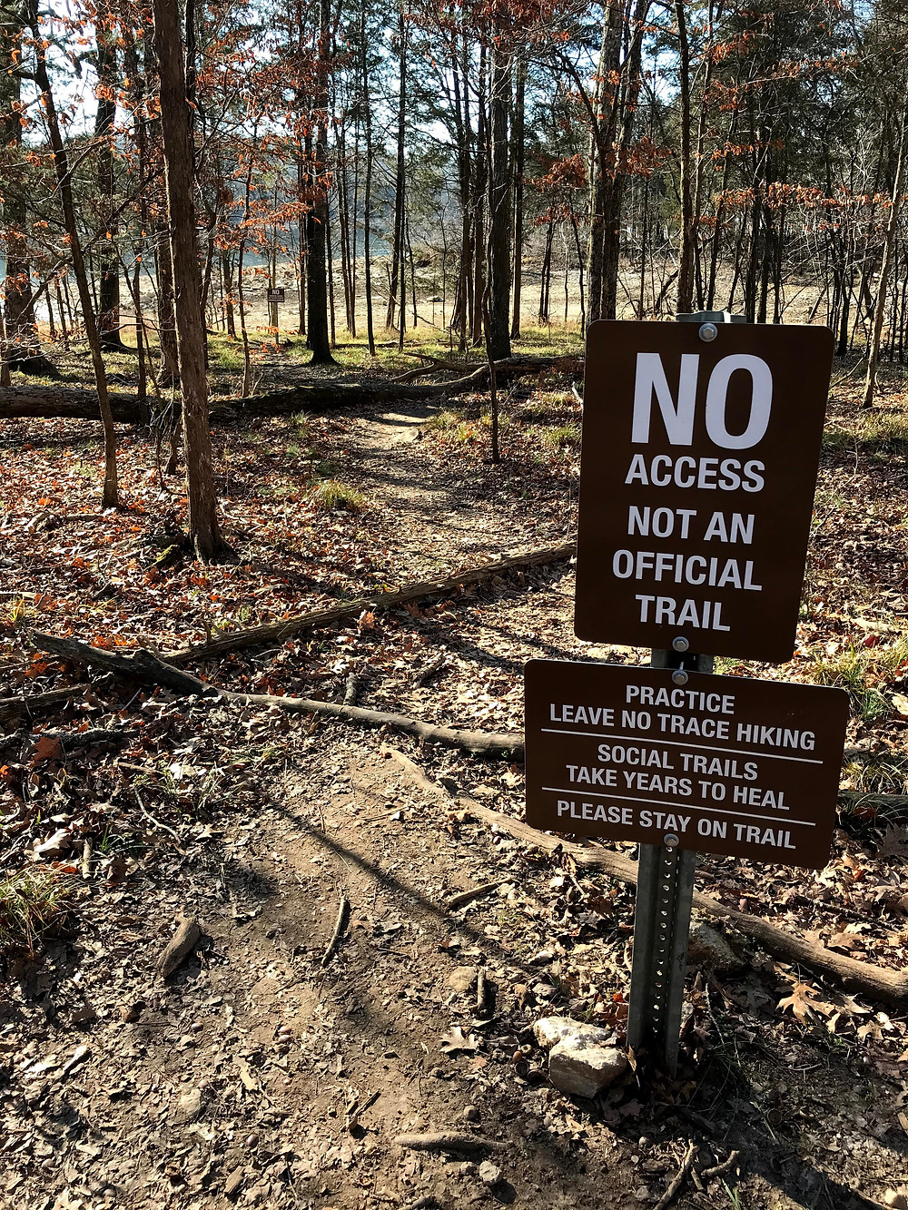 Sign next to a social trail asking hikers to stay on the official trail at Long Hunter State Park