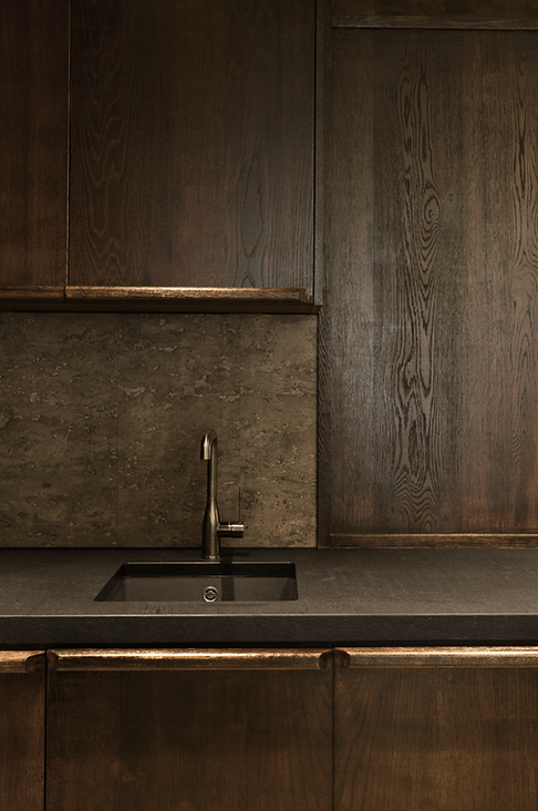 Moody rough sawn oak kitchen with black stone counter.
