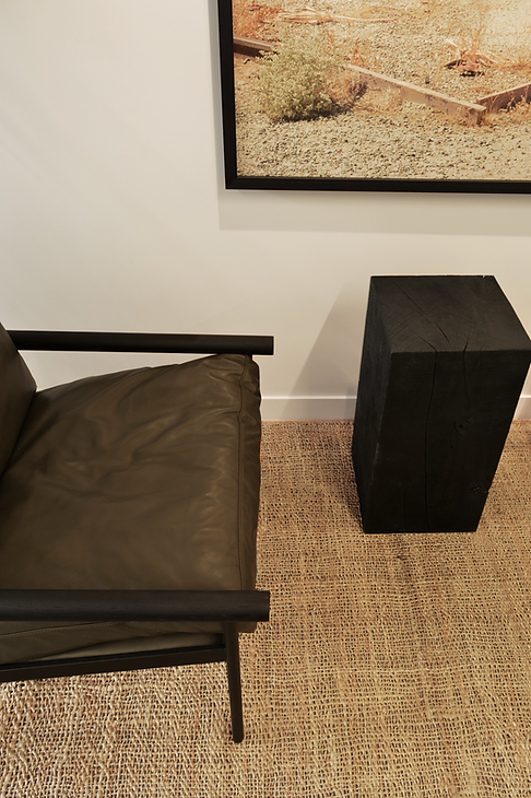 Interior seating detail with leather armchairs and jute rug creating a comfortable waiting nook