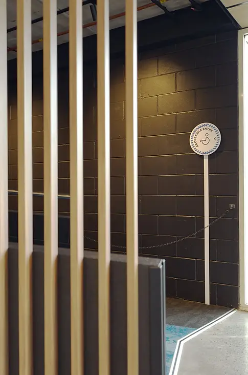 Accessibility ramp and signage with timber slat screen