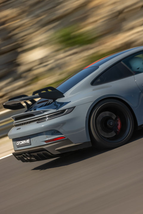 Porsche en pleine course sur circuit professionnel, capturée avec un effet de filé pour illustrer la vitesse