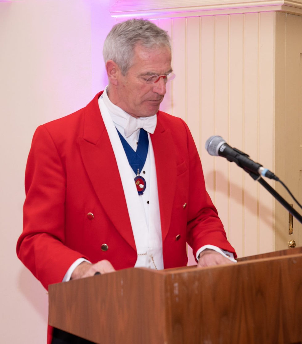 Close-up view of a toastmaster’s hand holding a note card with event schedule