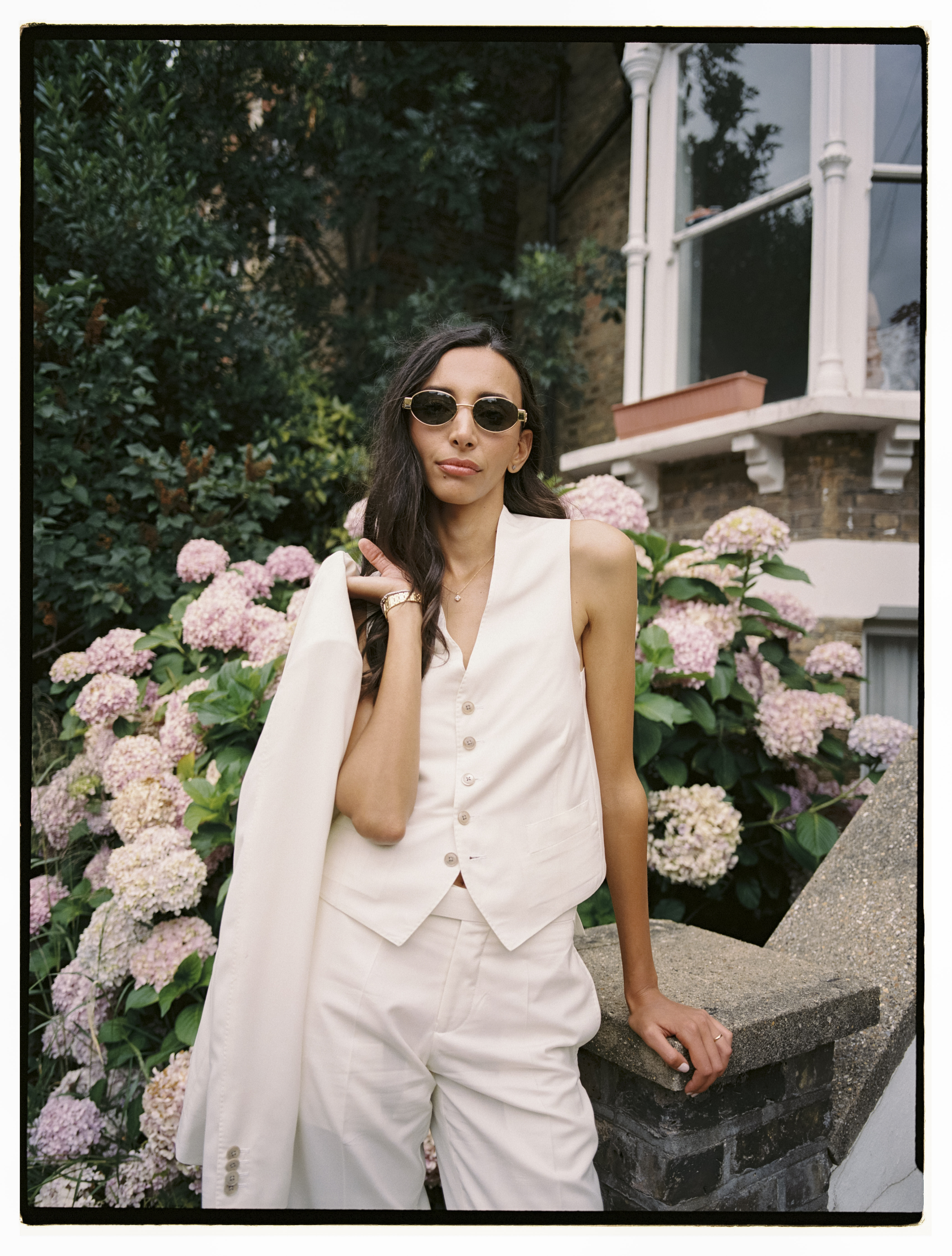 Iman's sage green pantsuit detail and Bottega Veneta bag — fashion editorial wedding London