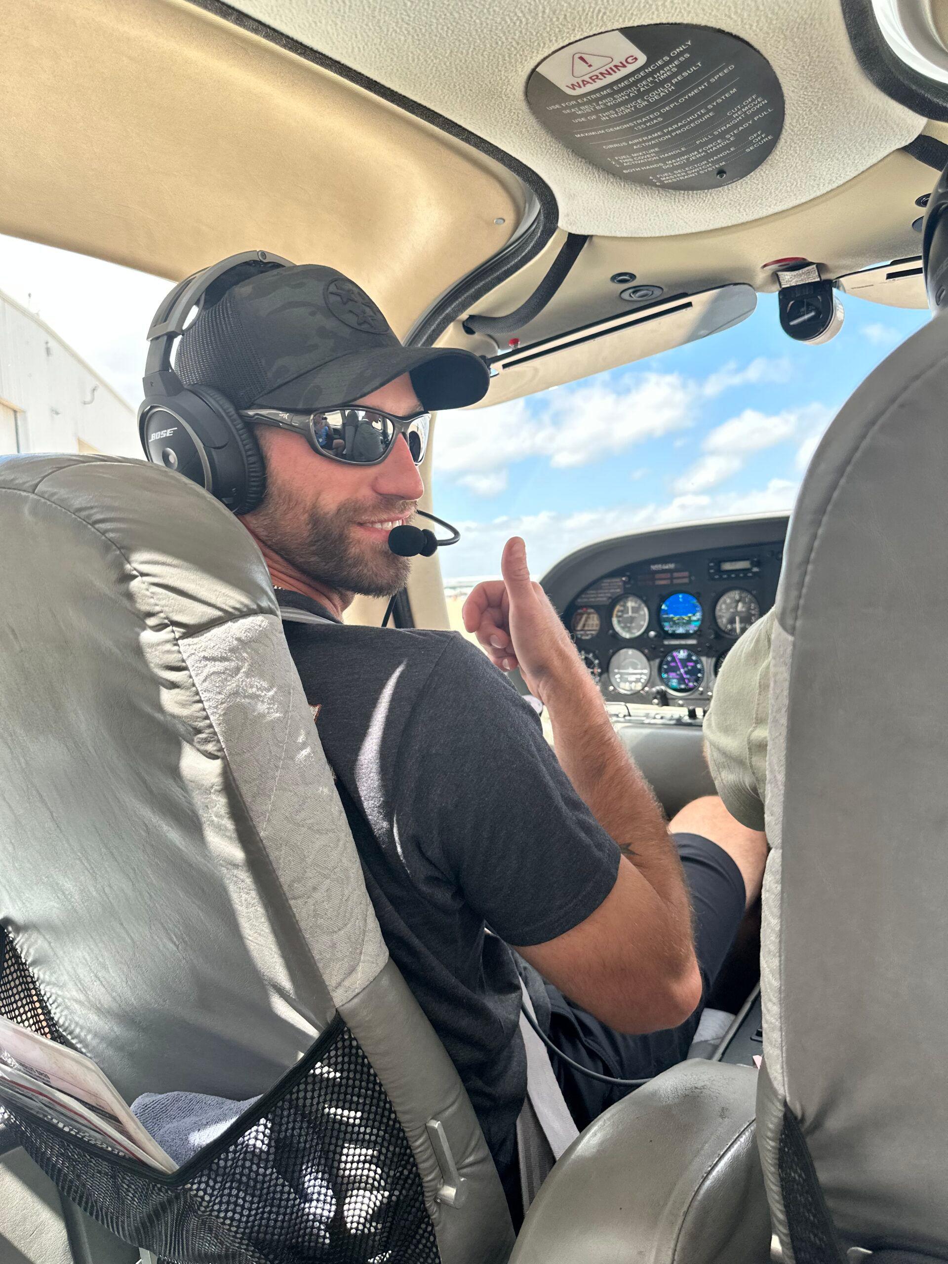 Pilot in cockpit giving a thumbs-up