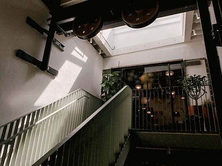 Hallway of stairs that are green with moody lighting