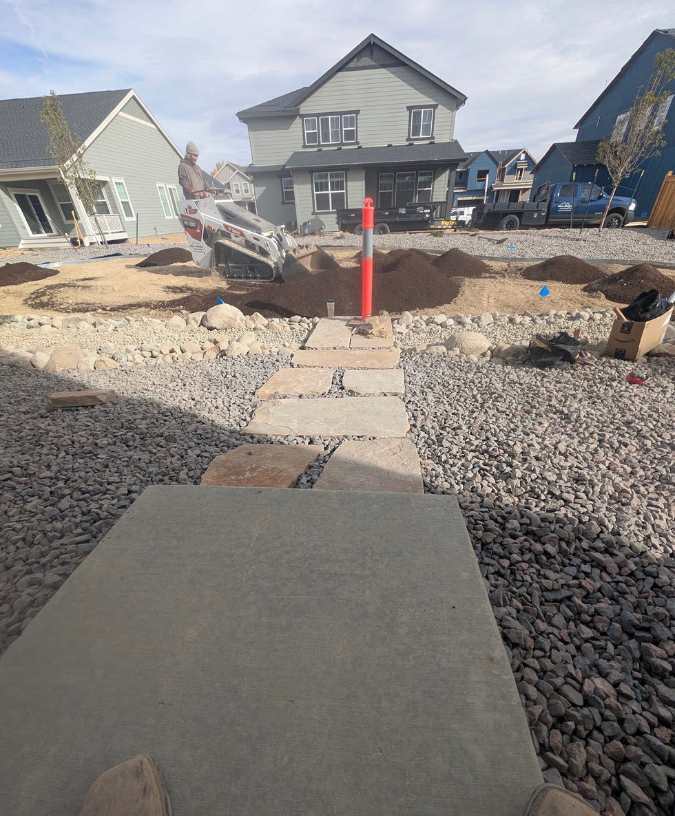 Backyard landscaping project in progress with grading, decorative rock and soil prep for sod 