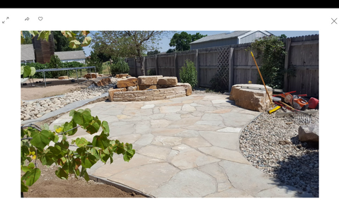 Rustic flagstone patio connected to a garden pathway with boulders
