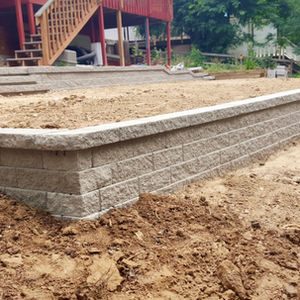 Structural retaining wall with clean lines and professional drainage, enhancing yard elevation