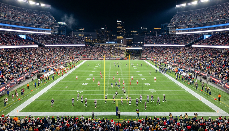 Wide-angle view of an American football stadium under night lights before a major NFL game