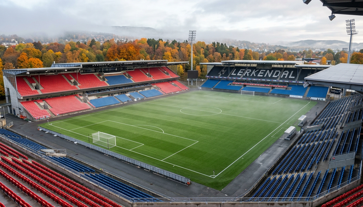 Wide-angle view of a Norwegian football stadium on a crisp October morning