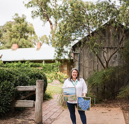 Artist Rachel Williamson with ChazownCreative holding Australian landscape and flower acrylic paintings