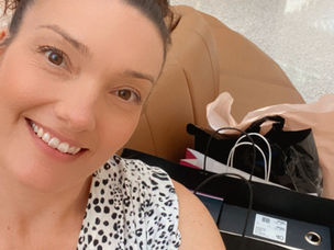 Nikki Voxx selfie smiling at the camera with shopping bags ine th background