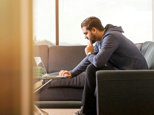 Racquet sports business owner working alone on laptop weighing a difficult decision