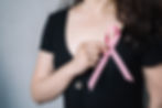 Femme tenant un ruban rose, symbole de la lutte contre le cancer du sein. A l'occasion d'Octobre rose découvrez le témoignage de femmes touchées par le cancer du sein