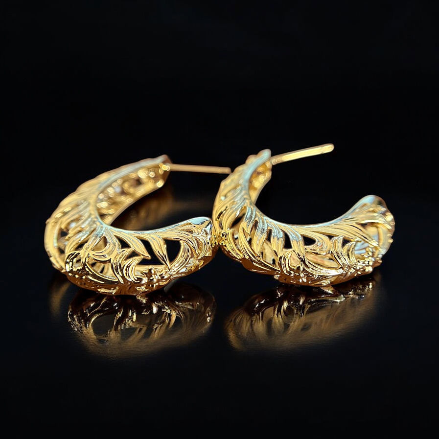 Model wearing Nova textured gold hoop earrings with carved tribal-inspired detailing.