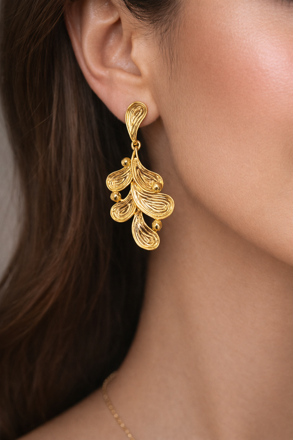 Gold leaf drop earrings with textured layered design on white background
