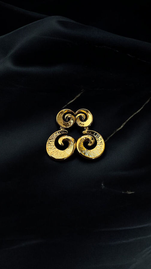 Noor tribal gold earrings displayed on black background