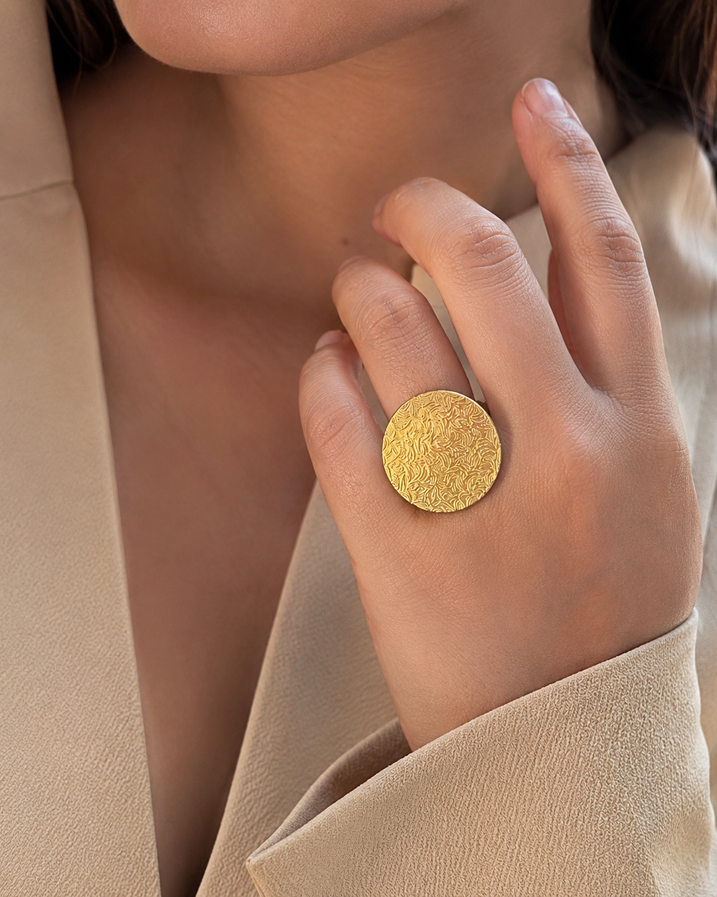 Woman wearing silver disc gold brass ring on finger