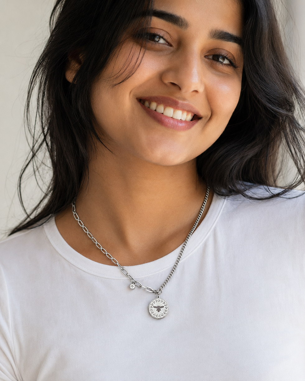 Young Indian woman wearing a stainless steel bee charm mixed chain necklace over a casual T-shirt