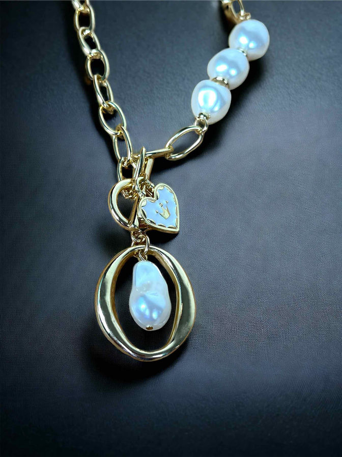 A luxurious 18K gold-plated link chain necklace featuring a heart-shaped charm alongside a shimmering pearl pendant
