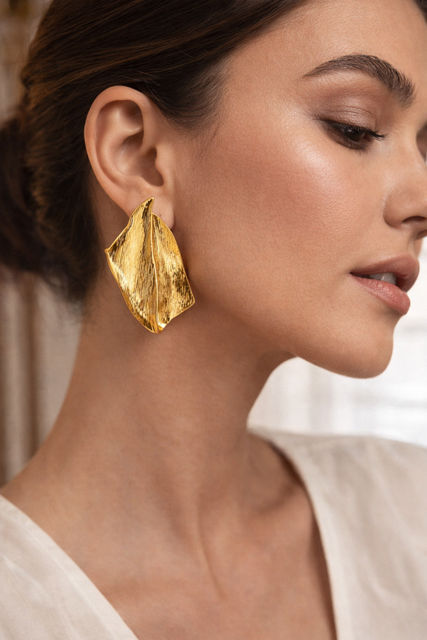 Gold sculptural statement earrings with abstract folded textured design