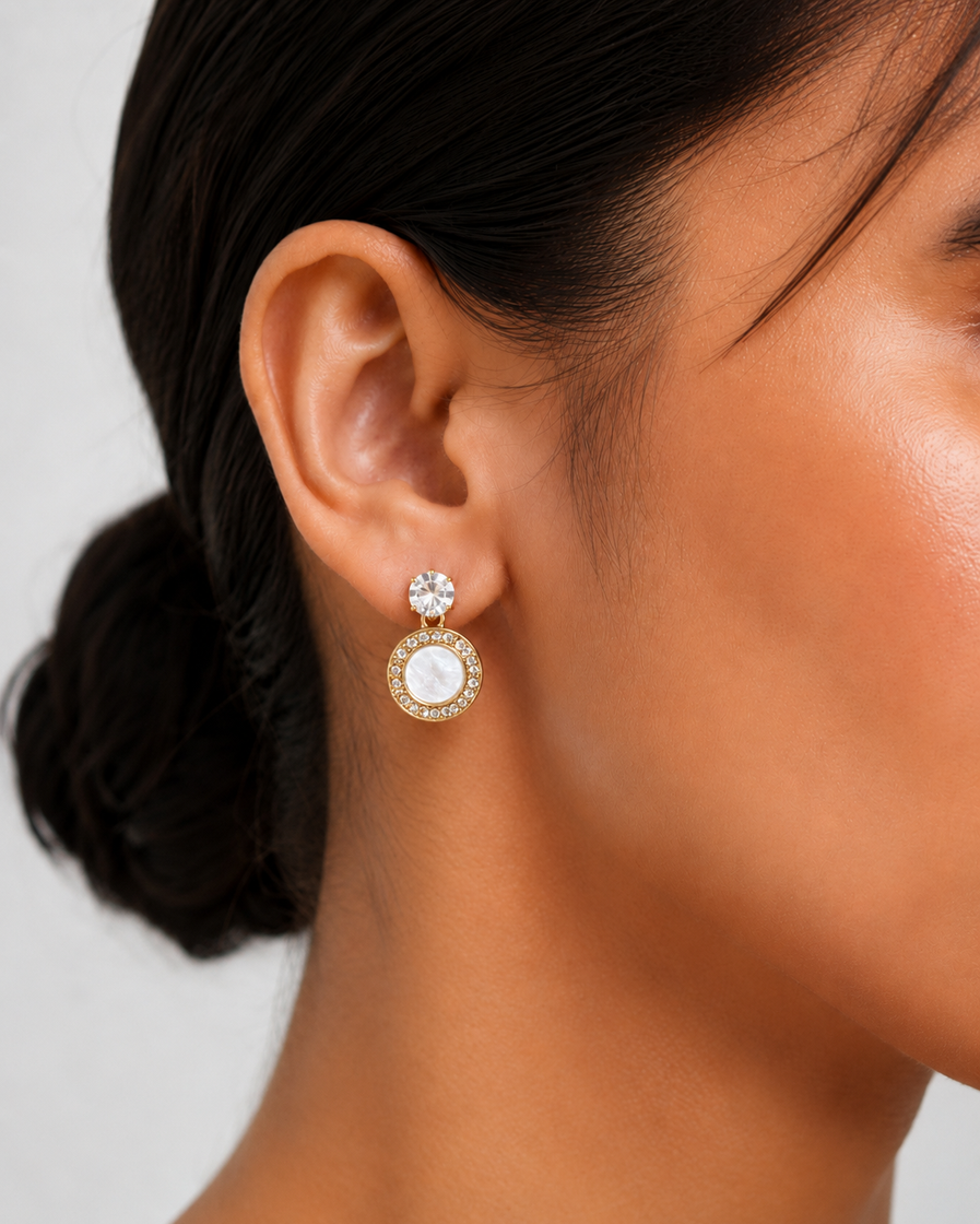 Silver round stud-drop earrings with clear crystal-style top and pearl-look centre worn by a model.