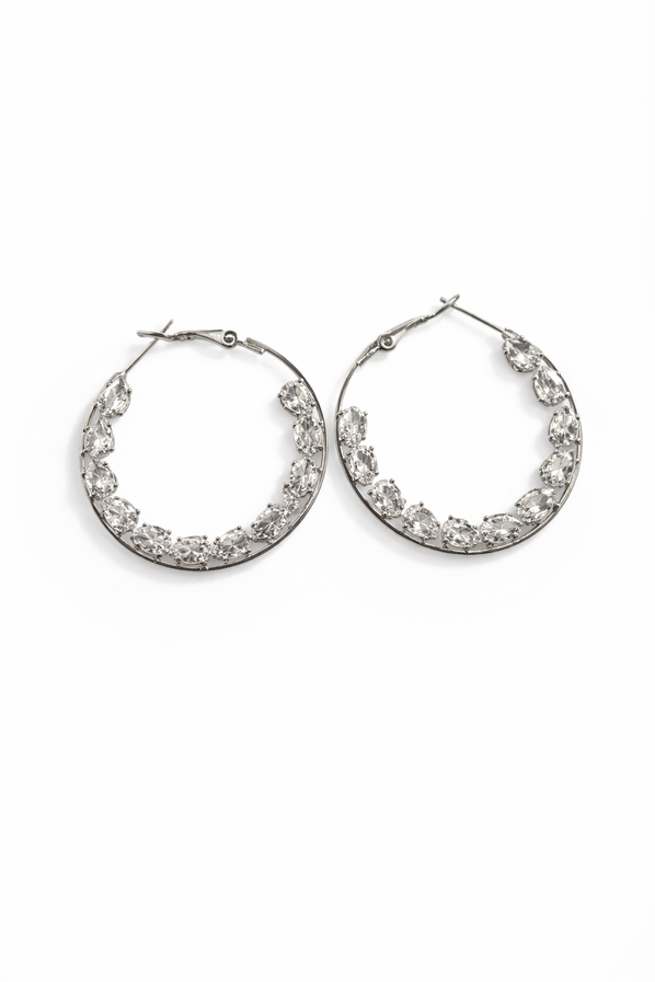 Silver crystal hoop earrings with teardrop stones on black background