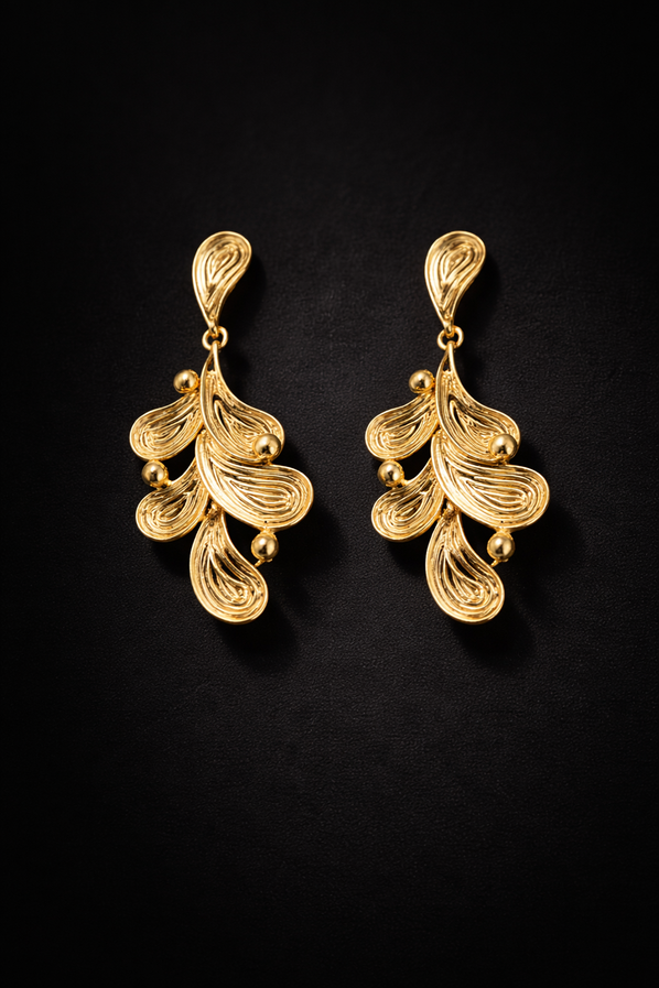 Women’s gold dangle earrings featuring botanical leaf inspired textured detailing