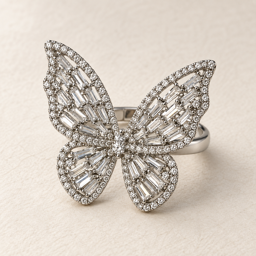 Large silver-tone butterfly ring with clear baguette-style stone detailing and an adjustable open band.