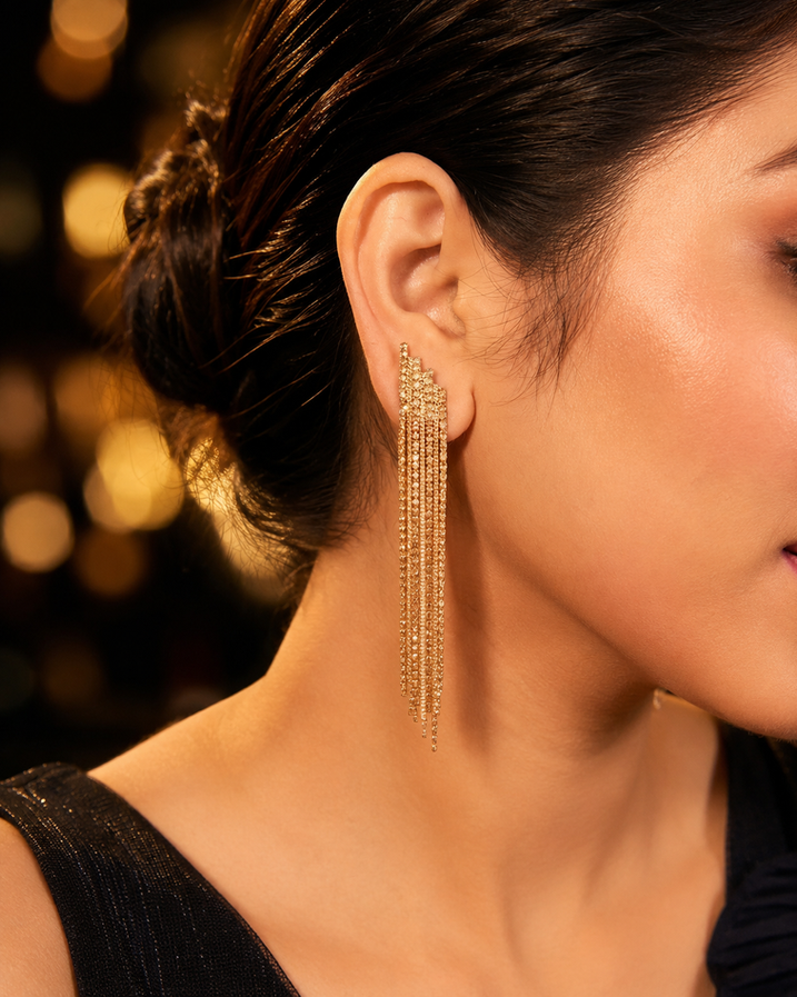 Golden crystal party dangler earrings worn by a model