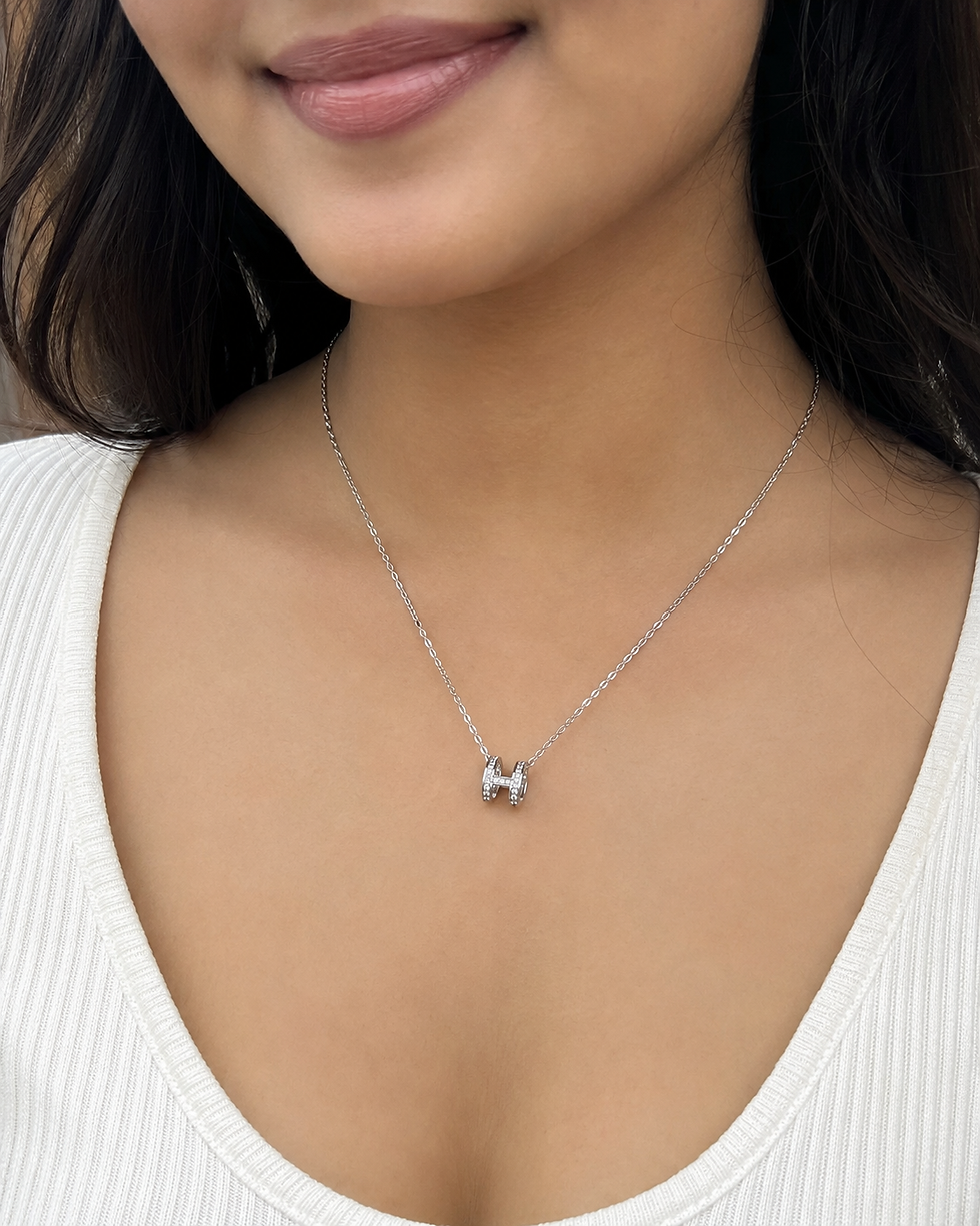 Silver H pendant worn by the model