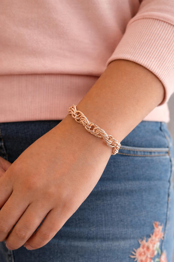 Rose gold chain link bracelet with toggle clasp on white background