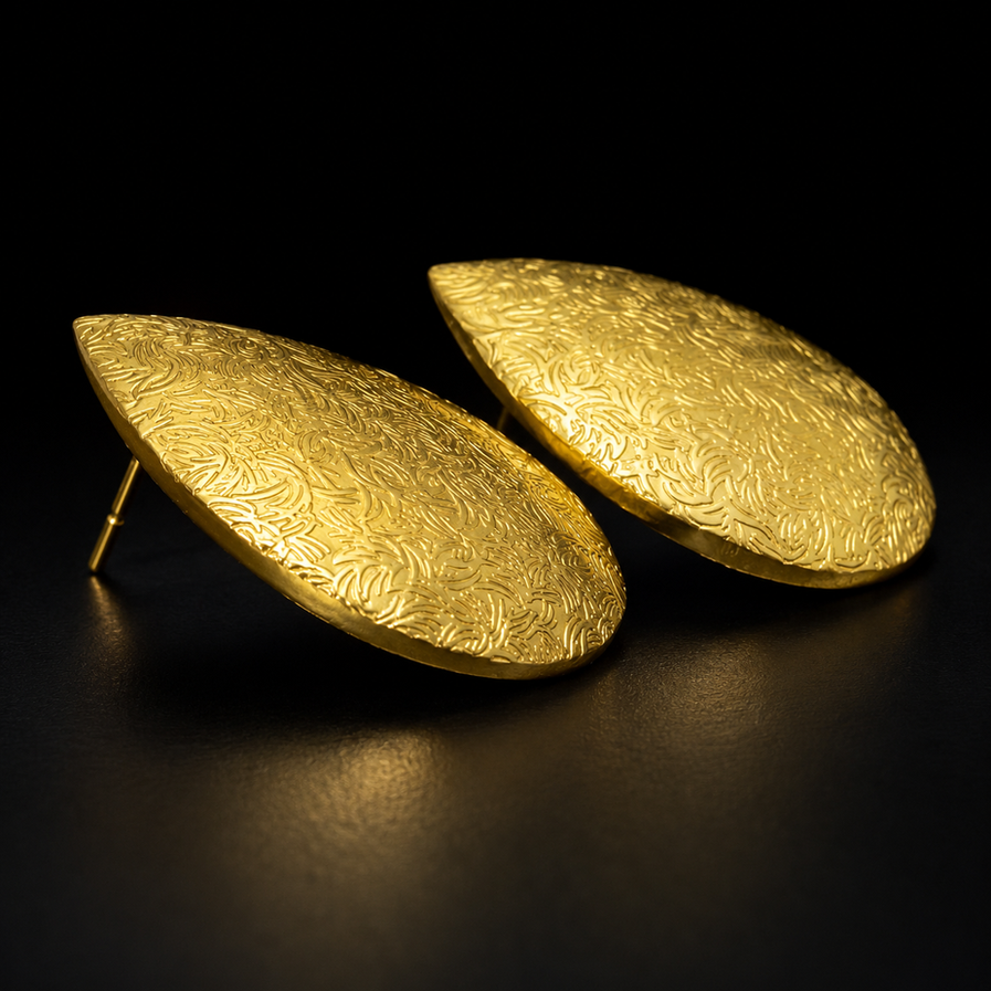 Pair of teardrop brass earrings with natural shadows