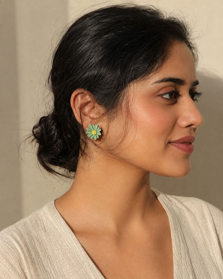 Woman wearing mismatched Korean floral stud earrings