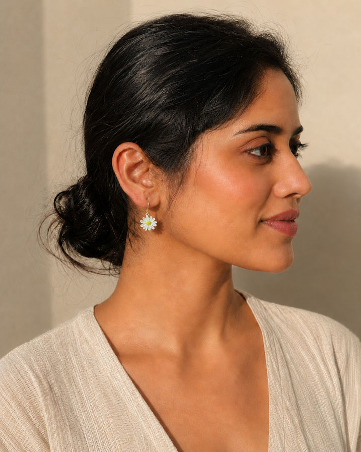 Woman wearing mismatched Korean floral stud earrings